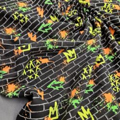 Dječji dres s grafiti uzorkom - crna baza s razigranim narančasto-zelenim grafiti uzorcima (185 g/m²)