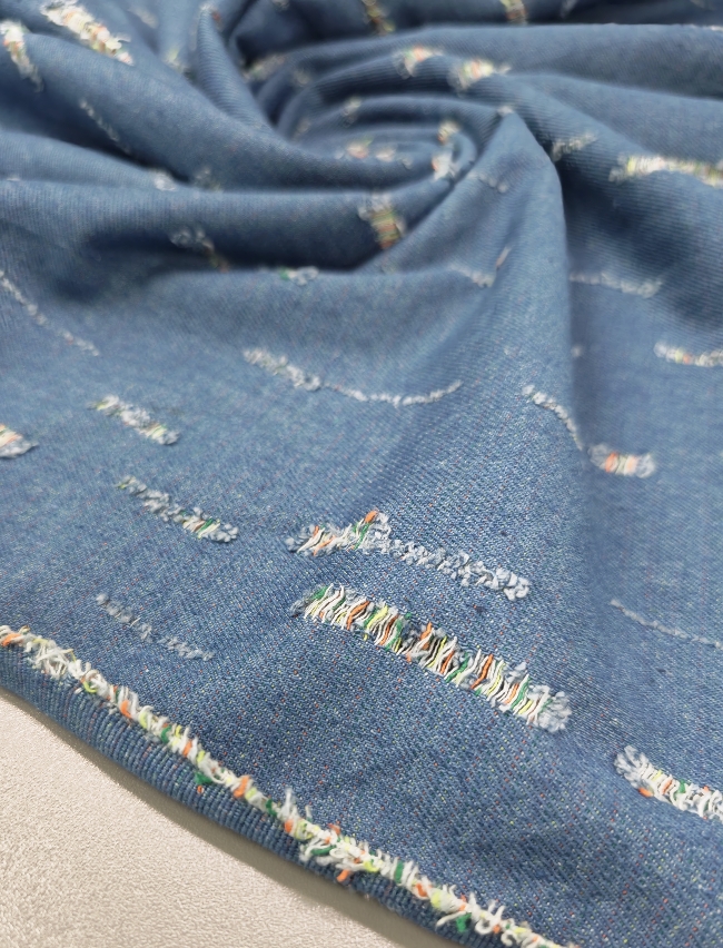 Plavi jeans s poderanim izgledom i šarenim nitima